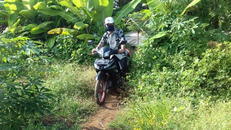 Ujang Setiawan Firdaus memacu motornya menuju rumah-rumah muridnya di Kabupaten Garut, Jawa Barat.